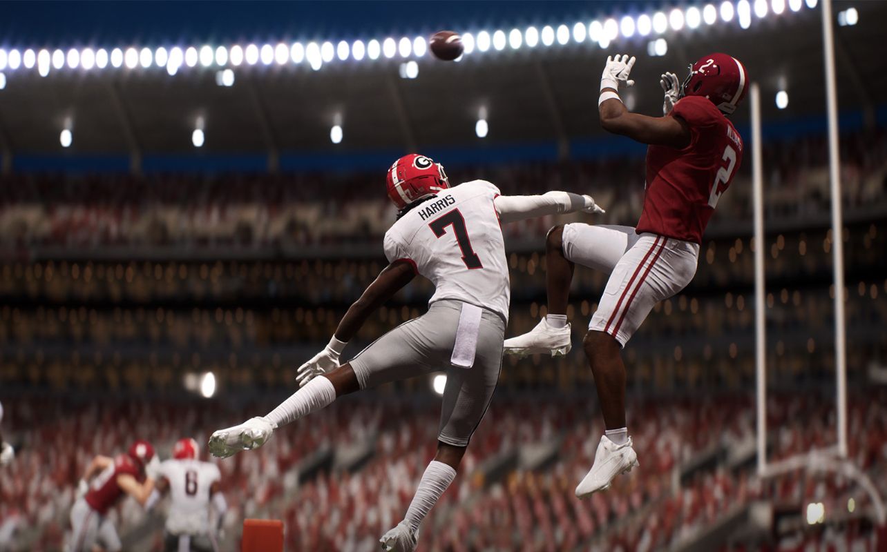 Two football players jump for the ball in a stadium. One in red, the other in white with "Harris 7" on his jersey. Bright stadium lights.