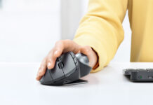 Person using Logitech MX Ergo mouse and trackball on desk.