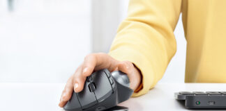 Person using Logitech MX Ergo mouse and trackball on desk.