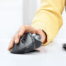 Person using Logitech MX Ergo mouse and trackball on desk.