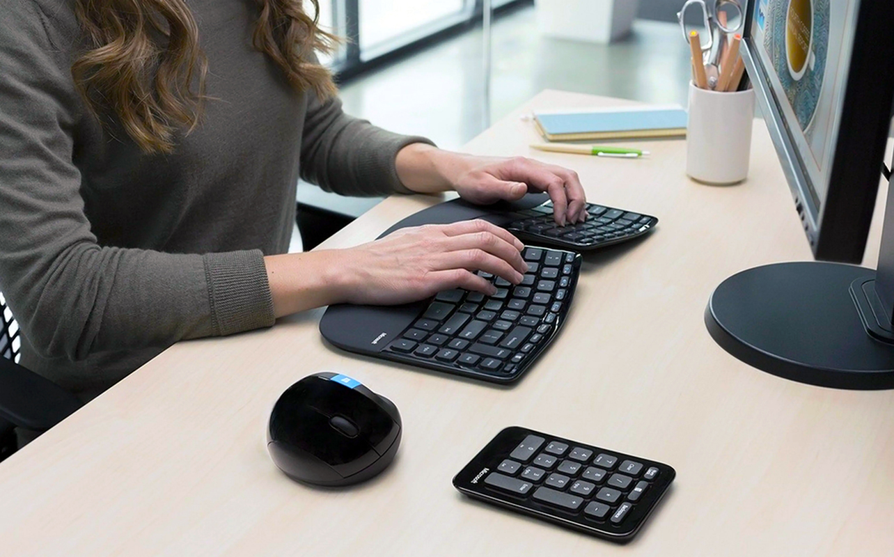 Woman using Microsoft Sculpt Ergonomic Desktop on a stand-up desk.