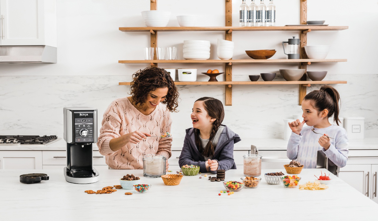mother and two daughters having fun, making ice cream together with a Ninja ice cream maker.