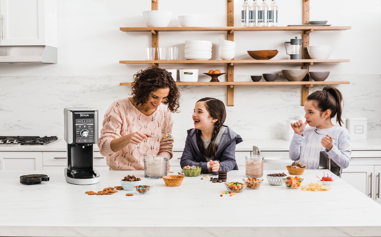 mother and two daughters having fun, making ice cream together with a Ninja ice cream maker.