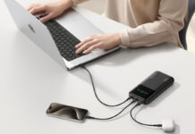 Hands on a laptop being charged with the INIU 27,000mAh power bank.