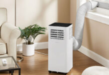 An Insignia portable air conditioner by the window in a living room.