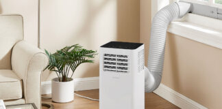 An Insignia portable air conditioner by the window in a living room.