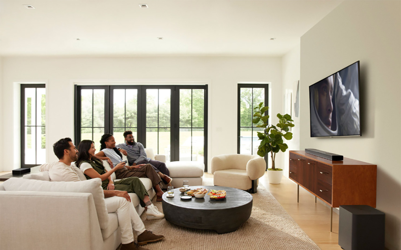 A family watching TV in a living room with the JBL Bar 1300x