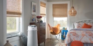A cylindrical portable air conditioner in a bedroom.