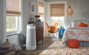A cylindrical portable air conditioner in a bedroom.