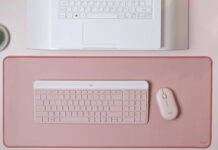 Logitech MK470 Slim Combo in pink on similar background in front of laptop.