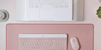 Logitech MK470 Slim Combo in pink on similar background in front of laptop.
