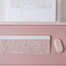 Logitech MK470 Slim Combo in pink on similar background in front of laptop.