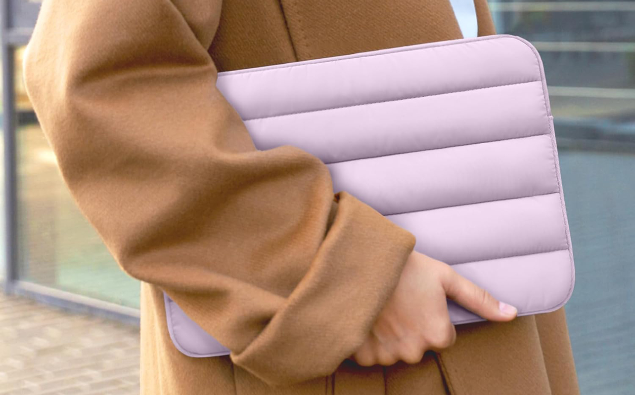 Woman holding a laptop in a protective sleeve case.