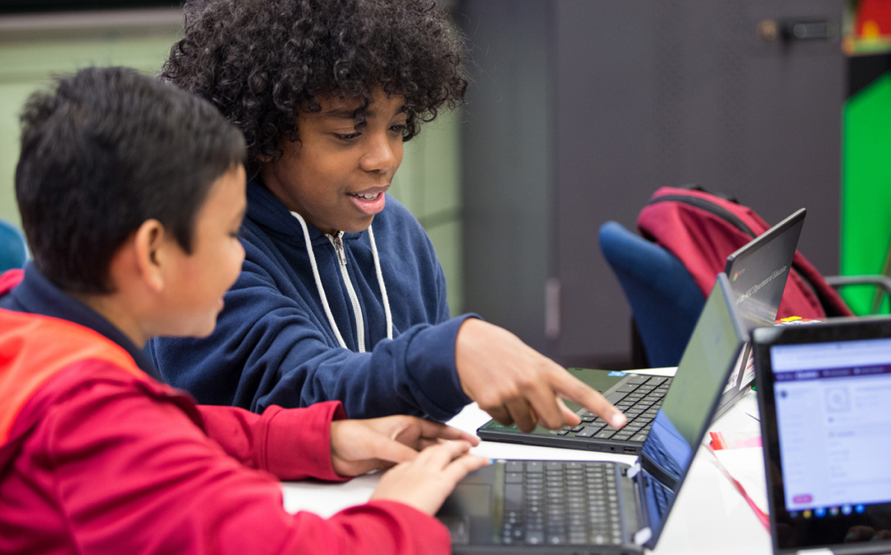 Young middle school students using Chromebooks in school.
