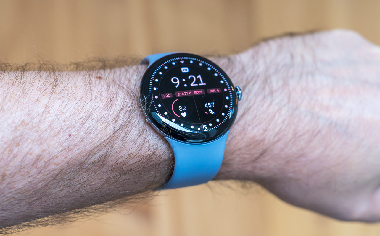 Google Pixel Watch 4 on left wrist showing home screen.