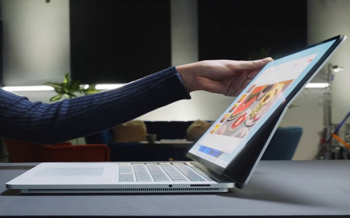 Woman opening Microsoft Surface premium Windows laptop.