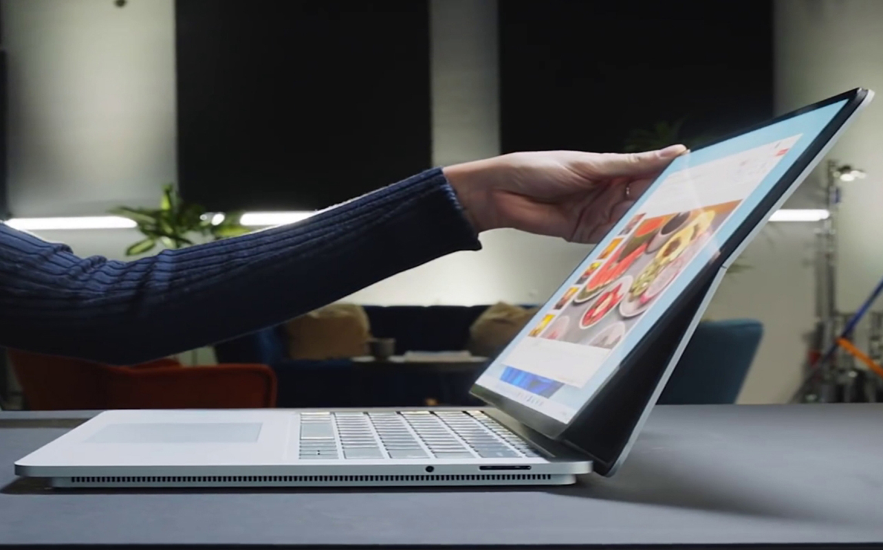 Woman opening Microsoft Surface premium Windows laptop.