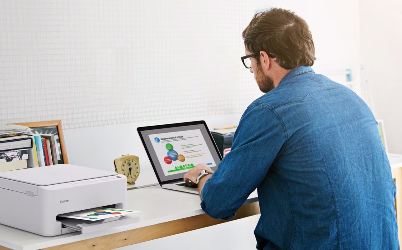 Man printing on a wireless printer from a laptop.