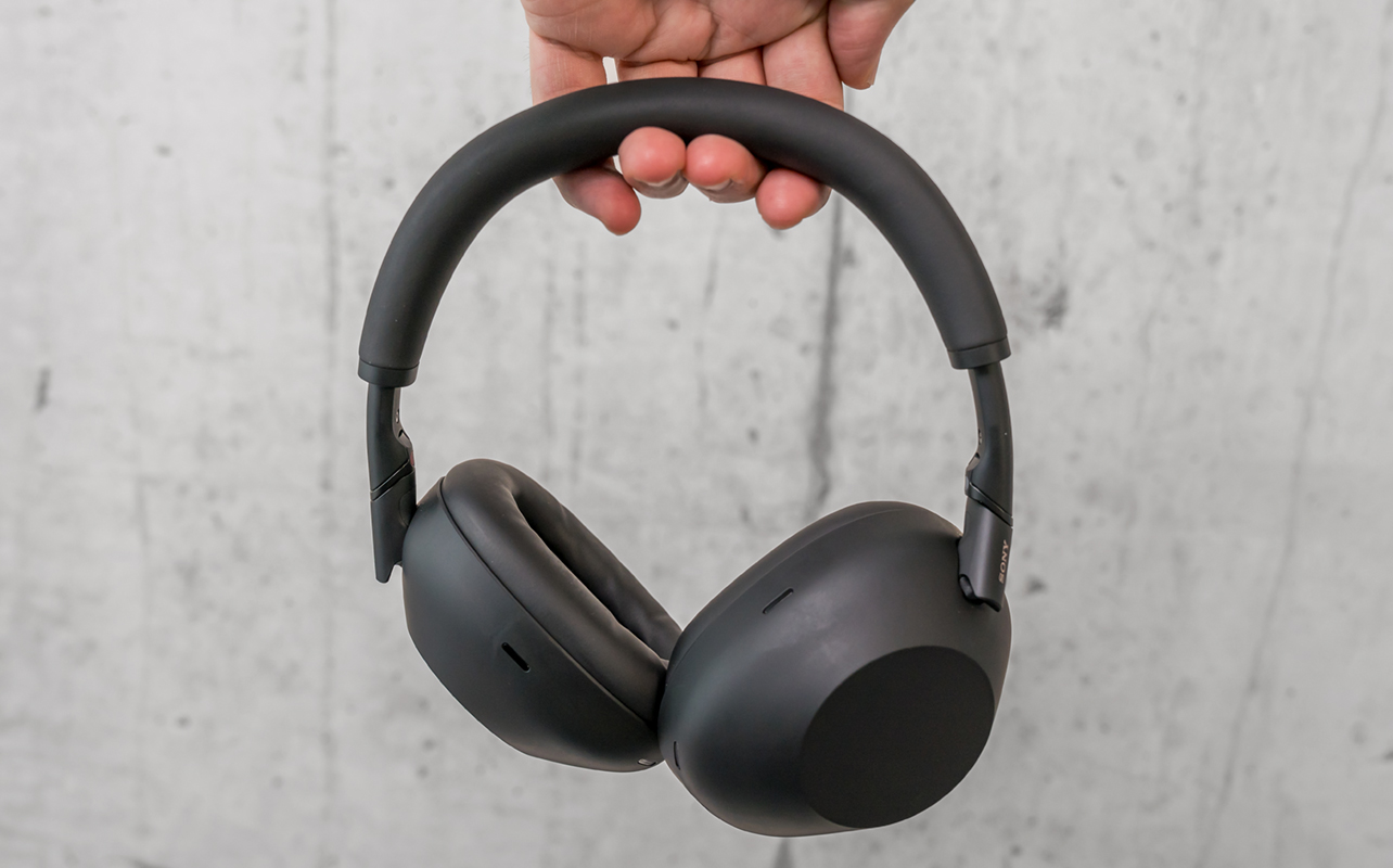 Sony WH-1000XM6 headphones in black held by the headband.
