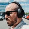 Profile view wearing Sony WH-1000XM6 headphones outdoors in parking lot.