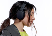 Younger girl wearing over-ear black headphones with eyes closed.