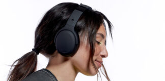 Younger girl wearing over-ear black headphones with eyes closed.