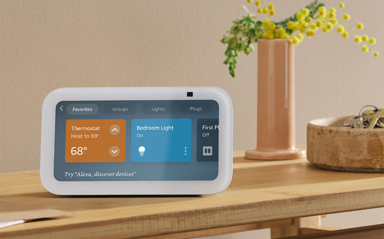An Amazon Echo Show 5 on a side table showing smart home controls.