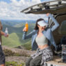 A man and woman sitting on a truckbed with an Anker Solix C300X portable power station