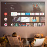 A family sitting outside watching TV using an Xgimi projector and projector screen.