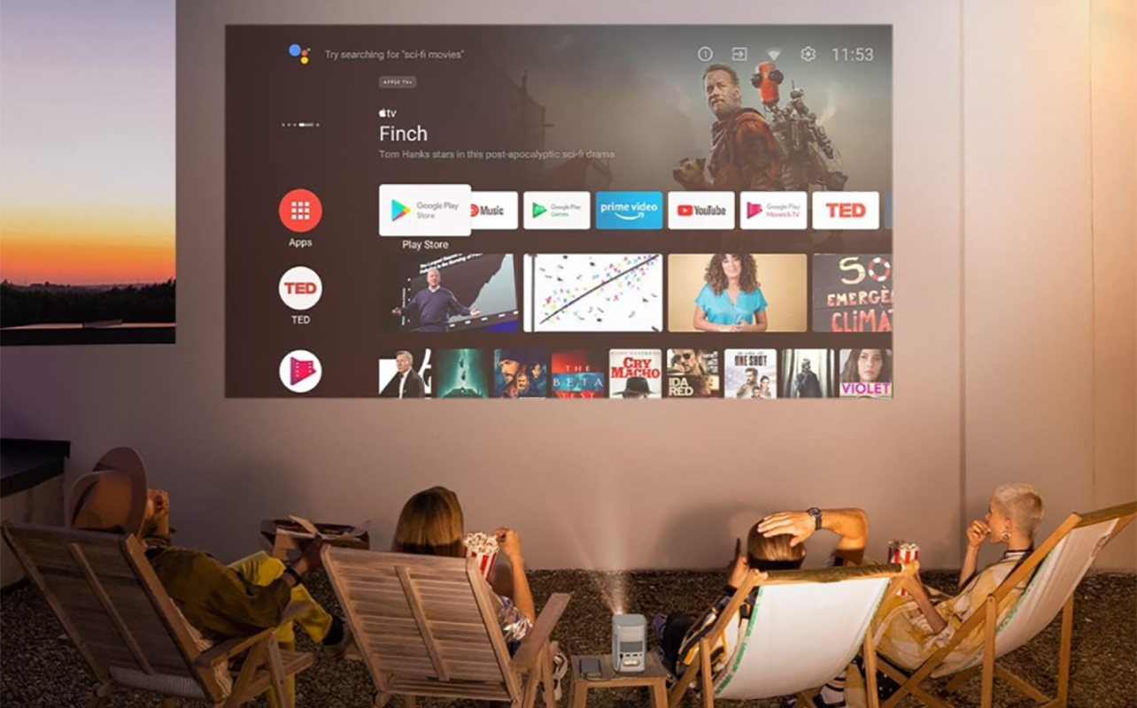 A family sitting outside watching TV using an Xgimi projector and projector screen.