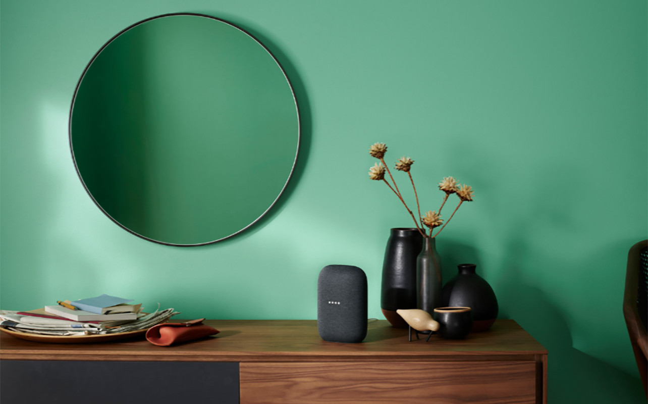 A Google Nest Audio smart speaker on a desk.