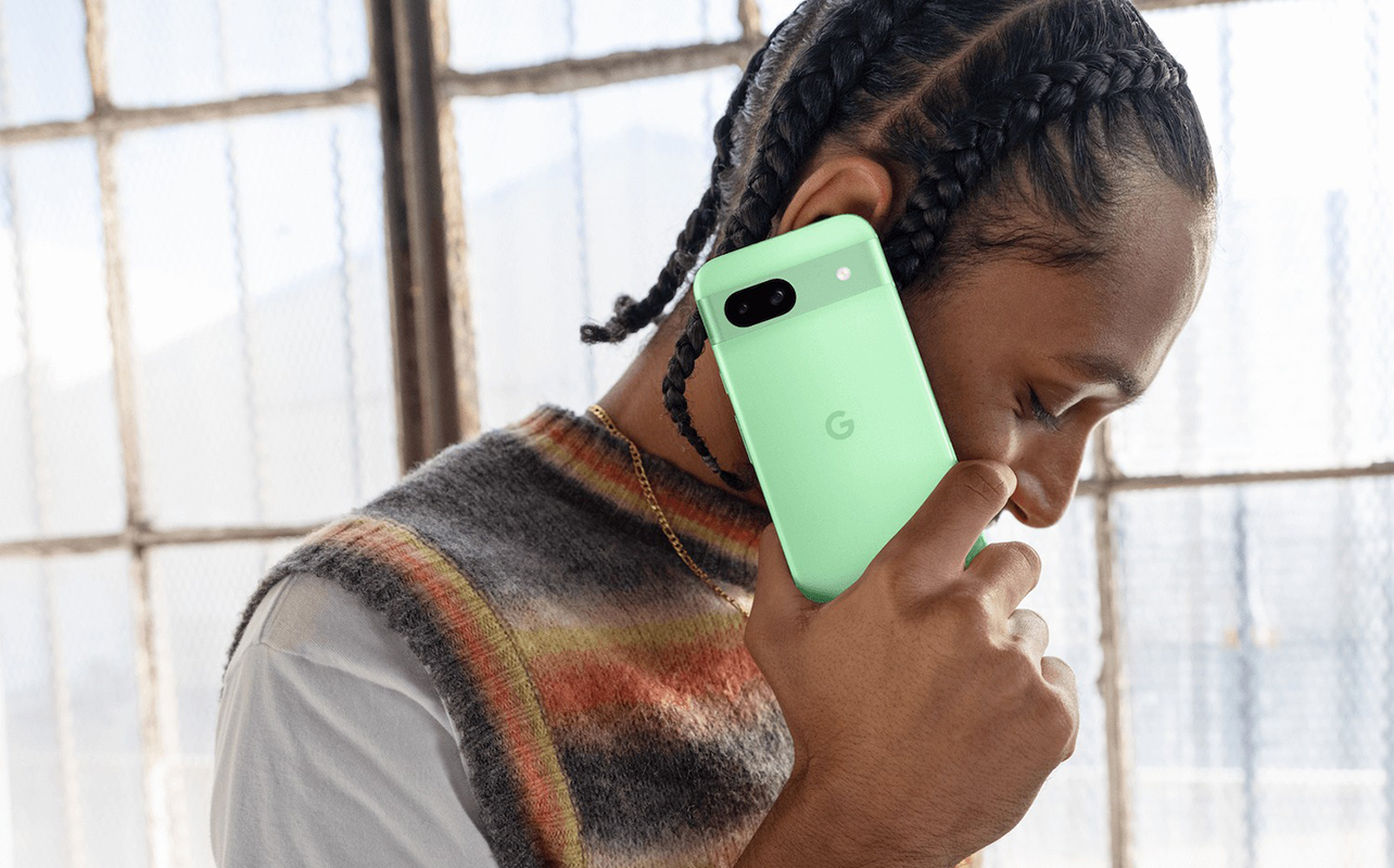 Side view of a young man with a Google Pixel 8a up to his ear.