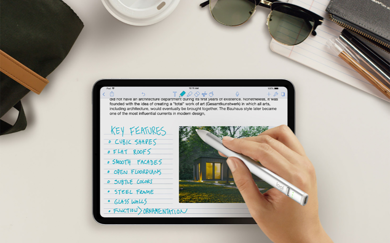 A hand using a Logitech Crayon digital pencil on a tablet.