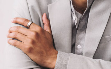 Smart rings vs. smartwatches: which wearable is right for you in 2026? A man's hand folded over his chest wearing the Oura Ring 3.
