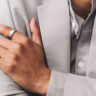 A man's hand folded over his chest wearing the Oura Ring 3.