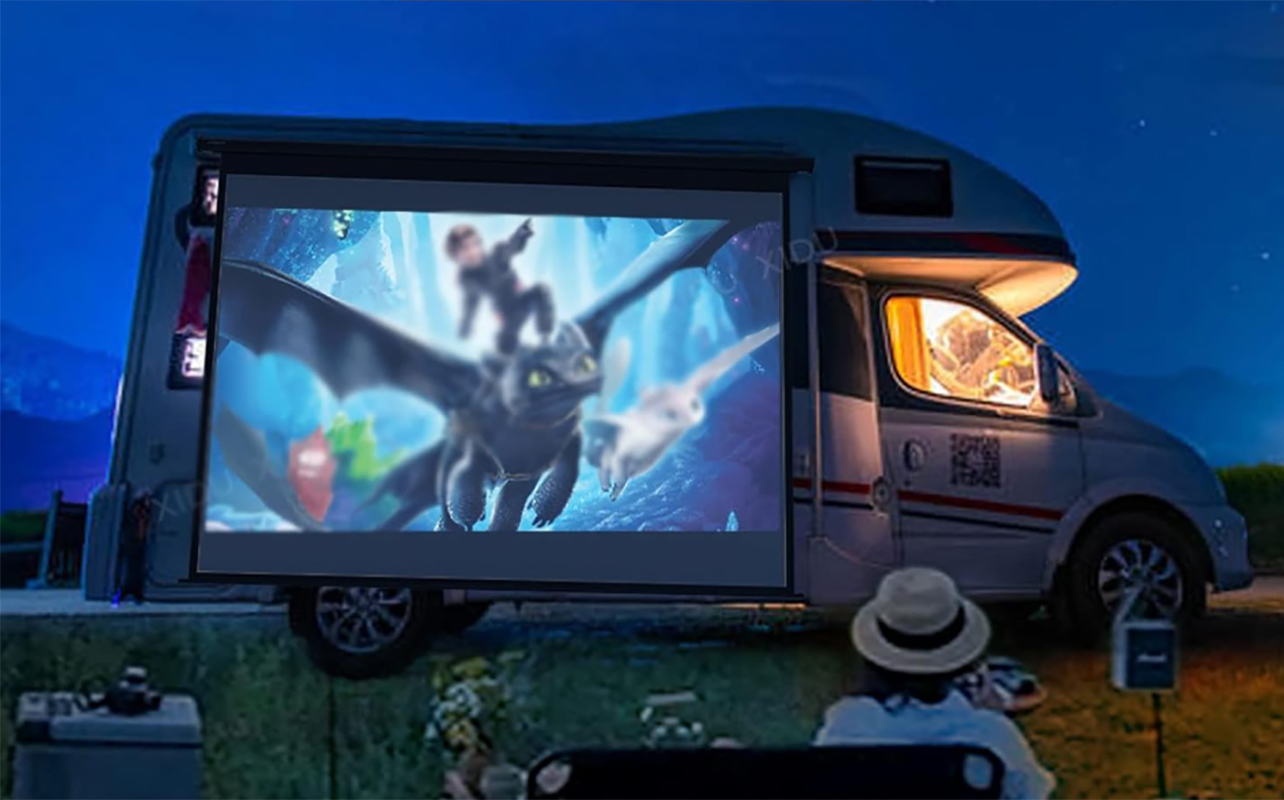 A portable mini projector projecting an image on the side of a truck.