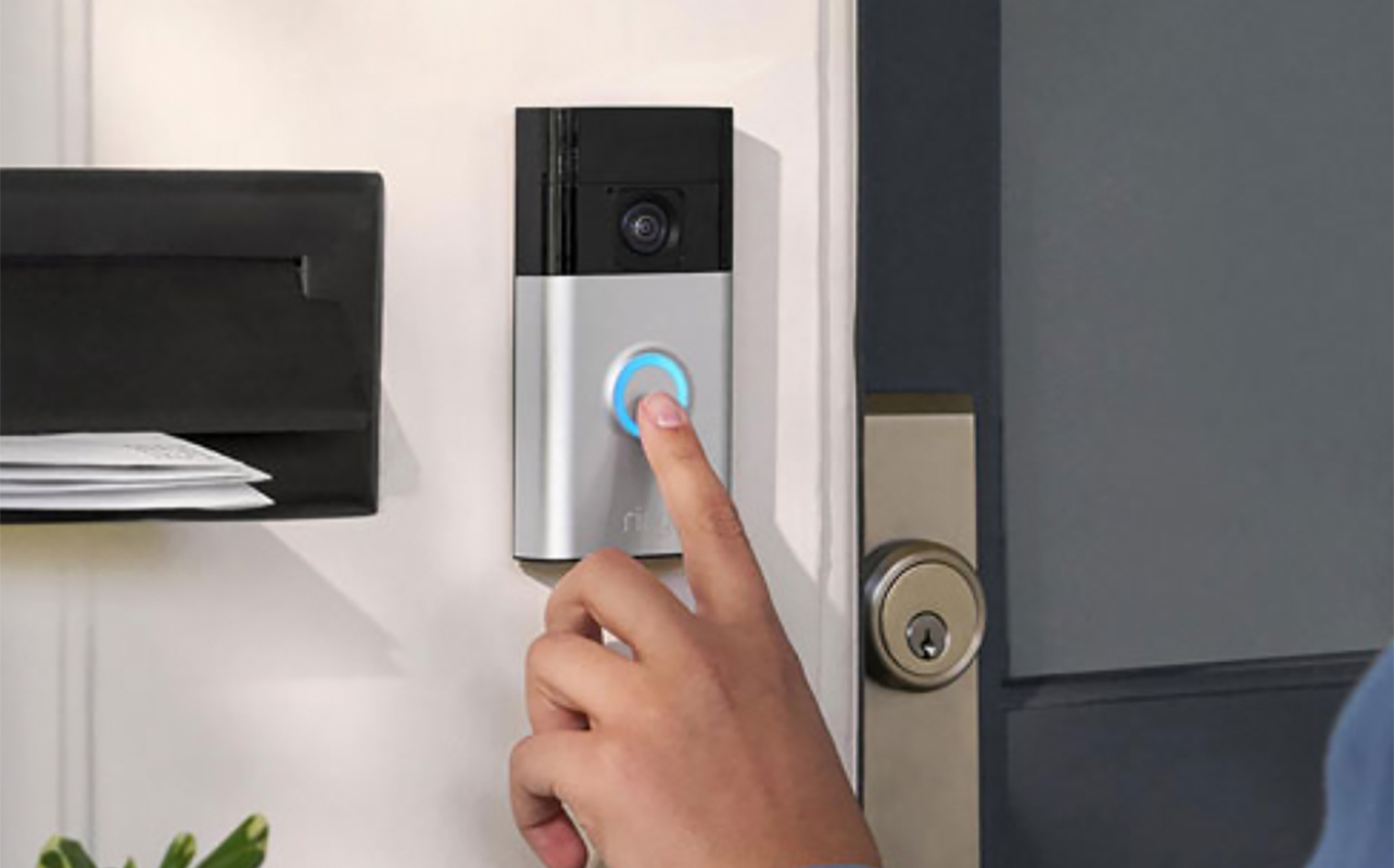 A finger touching a Ring video doorbell