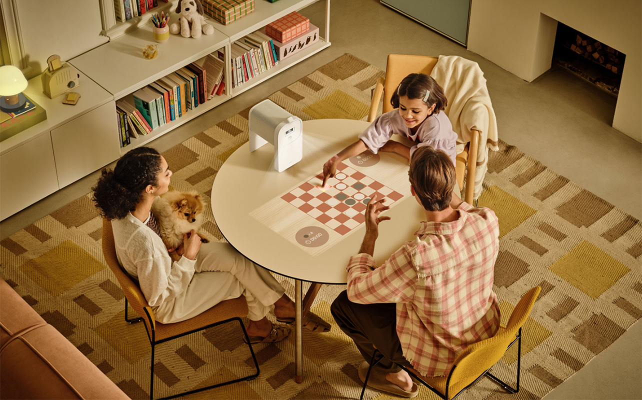 A family playing a game projected onto a table using the Samsung The Premiere 5 projector.