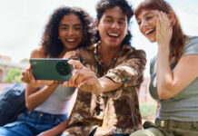 Three young students with the TCL 60XE smartphone taking a selfie.