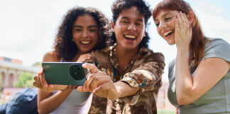 Three young students with the TCL 60XE smartphone taking a selfie.