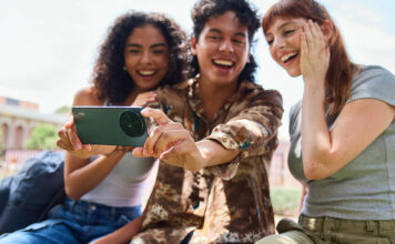 Three young students with the TCL 60XE smartphone taking a selfie.