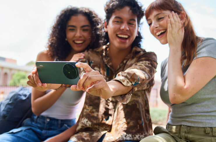 Three young students with the TCL 60XE smartphone taking a selfie.