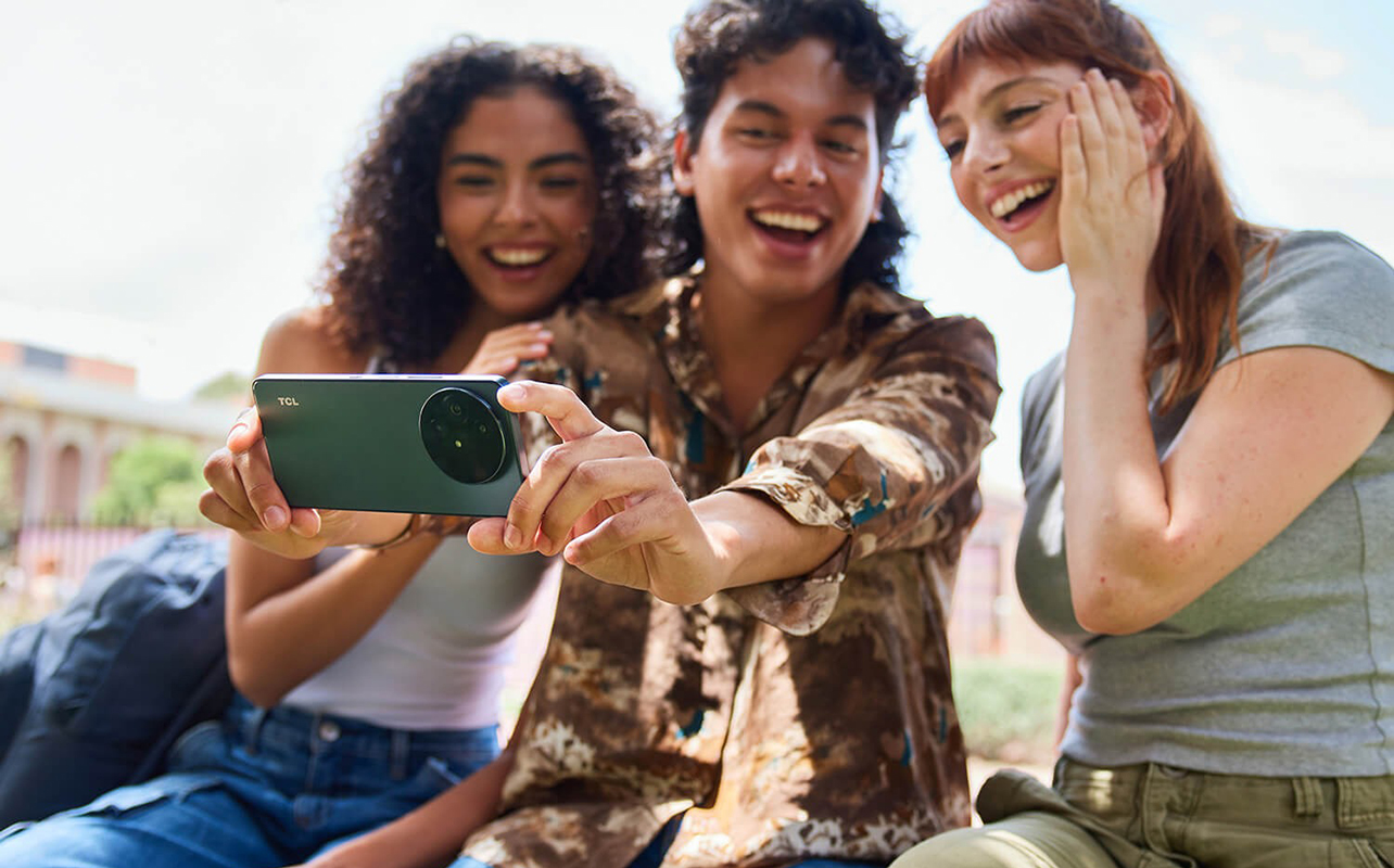 Three young students with the TCL 60XE smartphone taking a selfie.