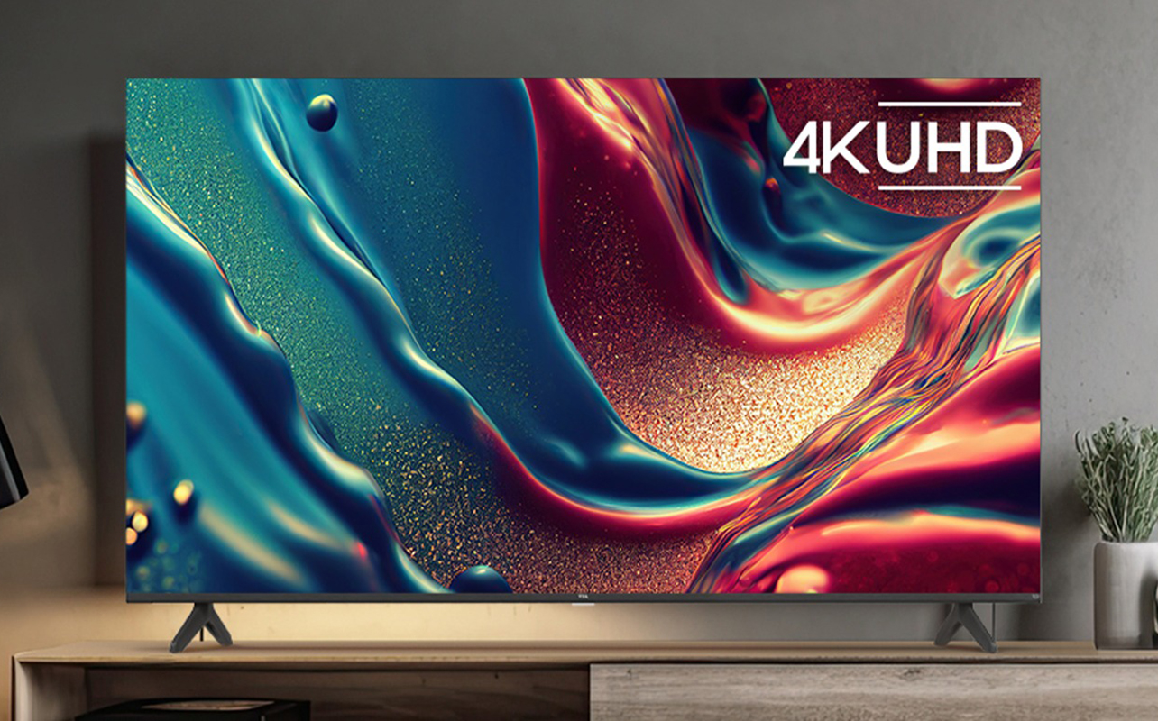 The TCL Q550F QLED TV on a stand.