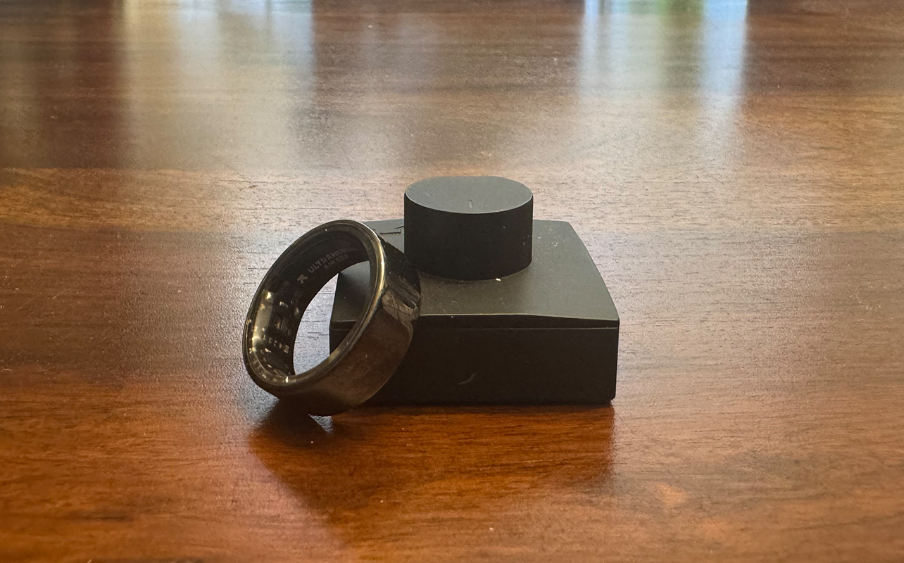 The Ultrahuman Ring Air beside its charger.