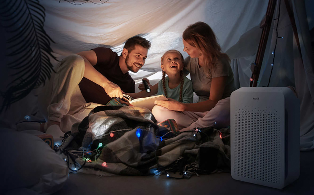 A family in a tent with a Winix air purifier