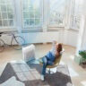 An overhead view of a woman in a living room with a Winix air purifier.