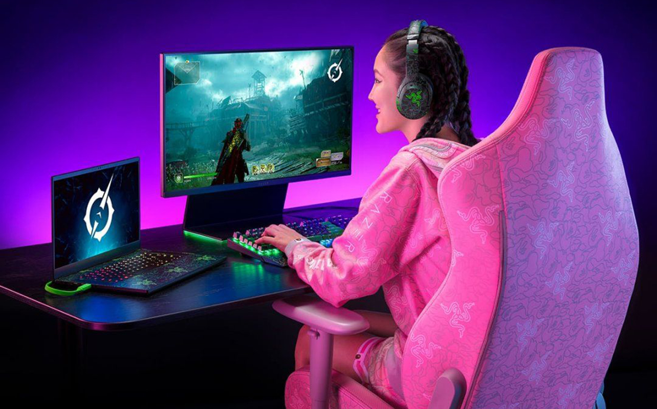 Woman playing a video game on a monitor wearing headphones.