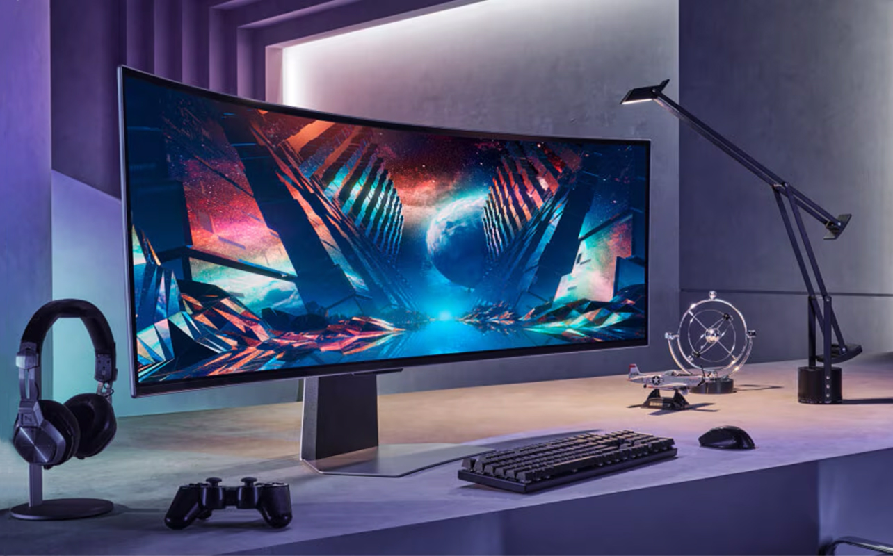 Curved gaming monitor standing on a desk with keyboard and controller nearby.
