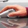 Man's right hand holding onto Ligtech MX Master 4 mouse